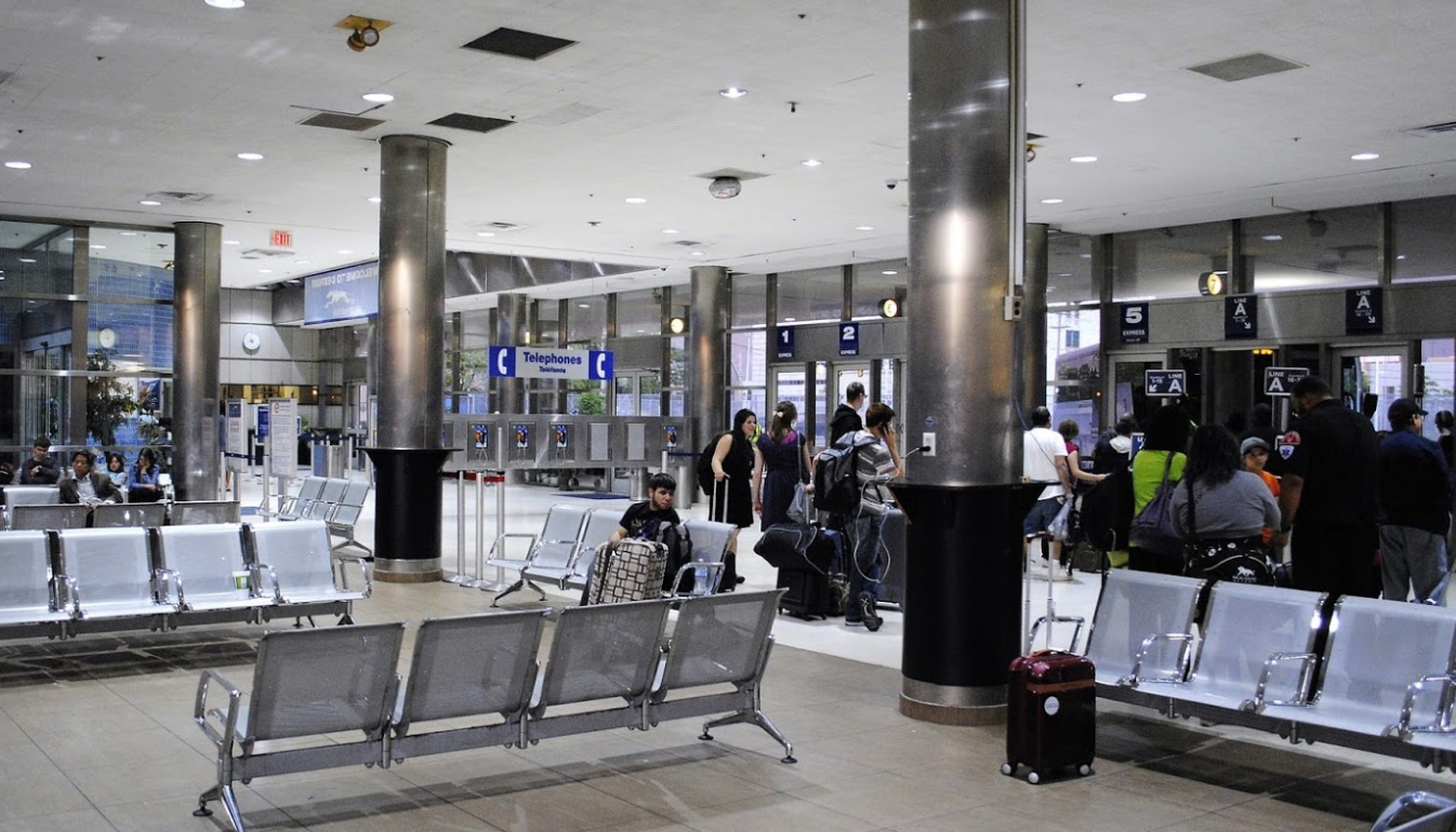 The interior of Detroit's Amtrak station, with rows of seating and people in line
