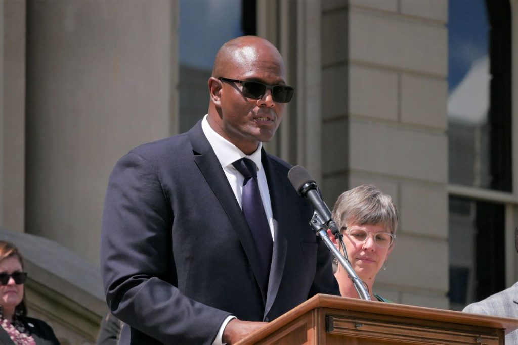 Michigan House Speaker Joe Tate speaks at a podium.