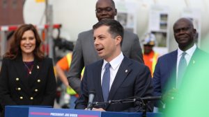 Secretary of Pete Buttigieg stands with Governor Whitmer and Lieutenant Governor Gilchrist.