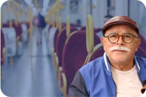 Older white man on a train with a faded blue background