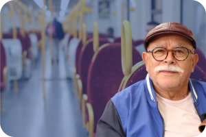Older white man on a train with a faded blue background