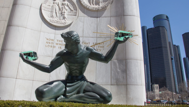 Spirit of Detroit holding two DDOT buses
