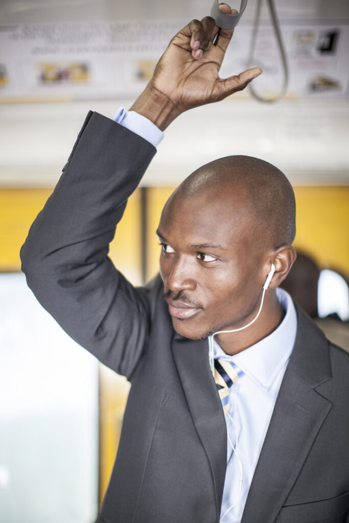 African businessman in the train hanging on a strap for balance