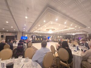 TRU's 25th anniversary gala, in a fancy event center with a stage in the photos center.