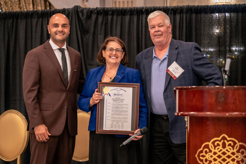 Assad Turfe, Megan, and Tim Killeen, posing with TRU's testimonial resolution from Wayne County.