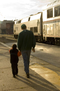 Man and child alongside train