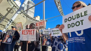 Crowd at Double DDOT rally, holding signs for Double DDOT and to respect bus driver wages